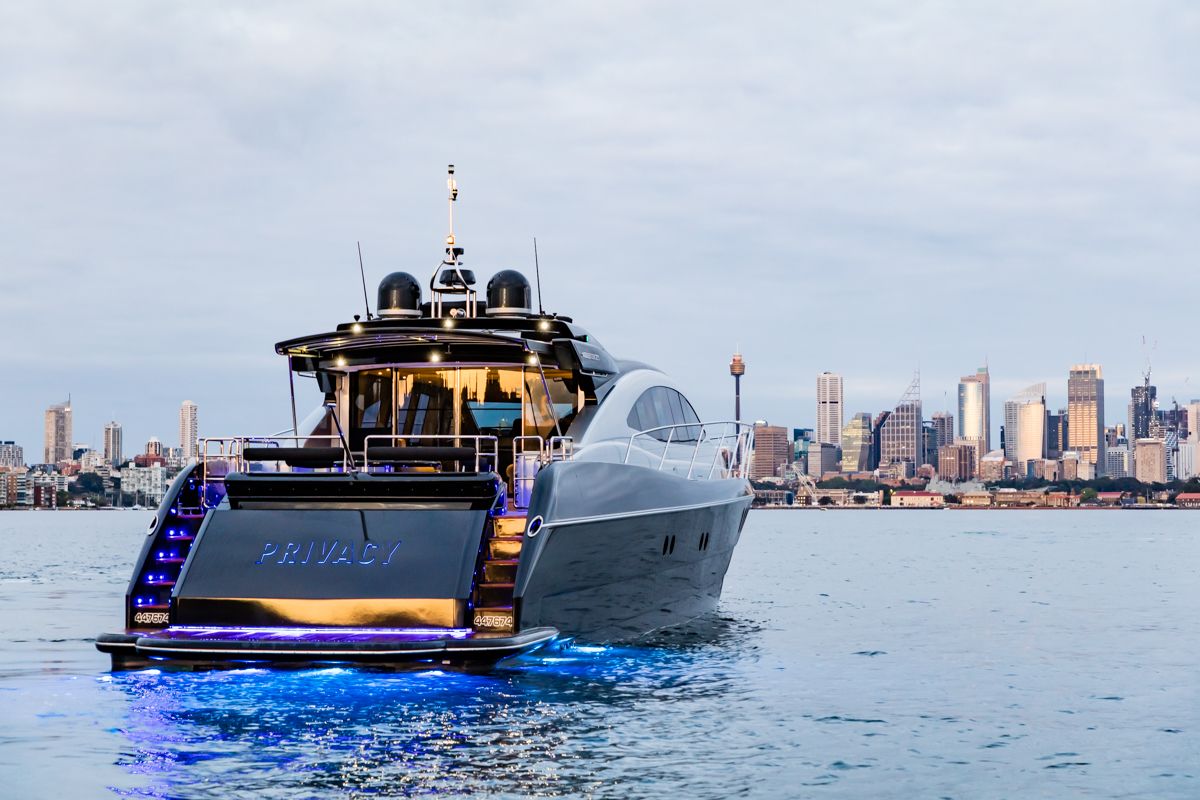 PRIVACY at dusk with underwater lights glowing, Sydney city skyline behind